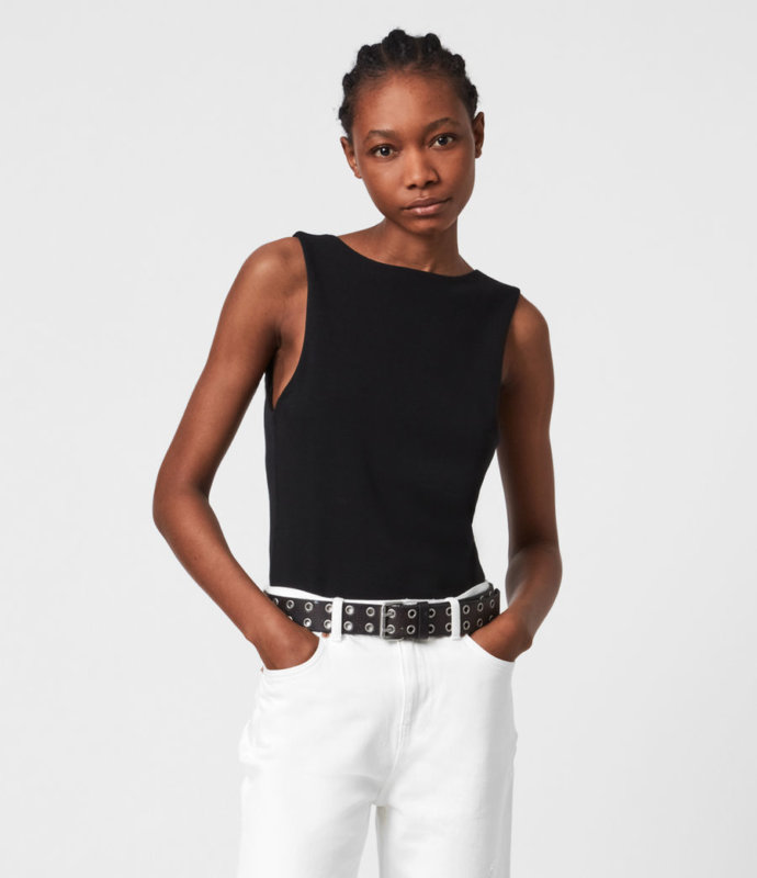 A MODEL WEARING A BLACK BODYSUIT AND WHITE TROUSERS ADVERTISING ALL SAINTS